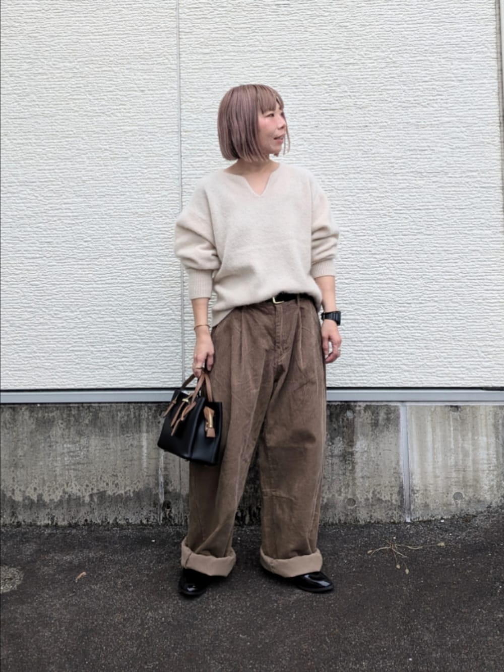 ベージュ系のその他パンツ、ブラック系のローファー、ブラック系のハンドバッグを着用したレディースの秋コーディネートの2枚目の写真