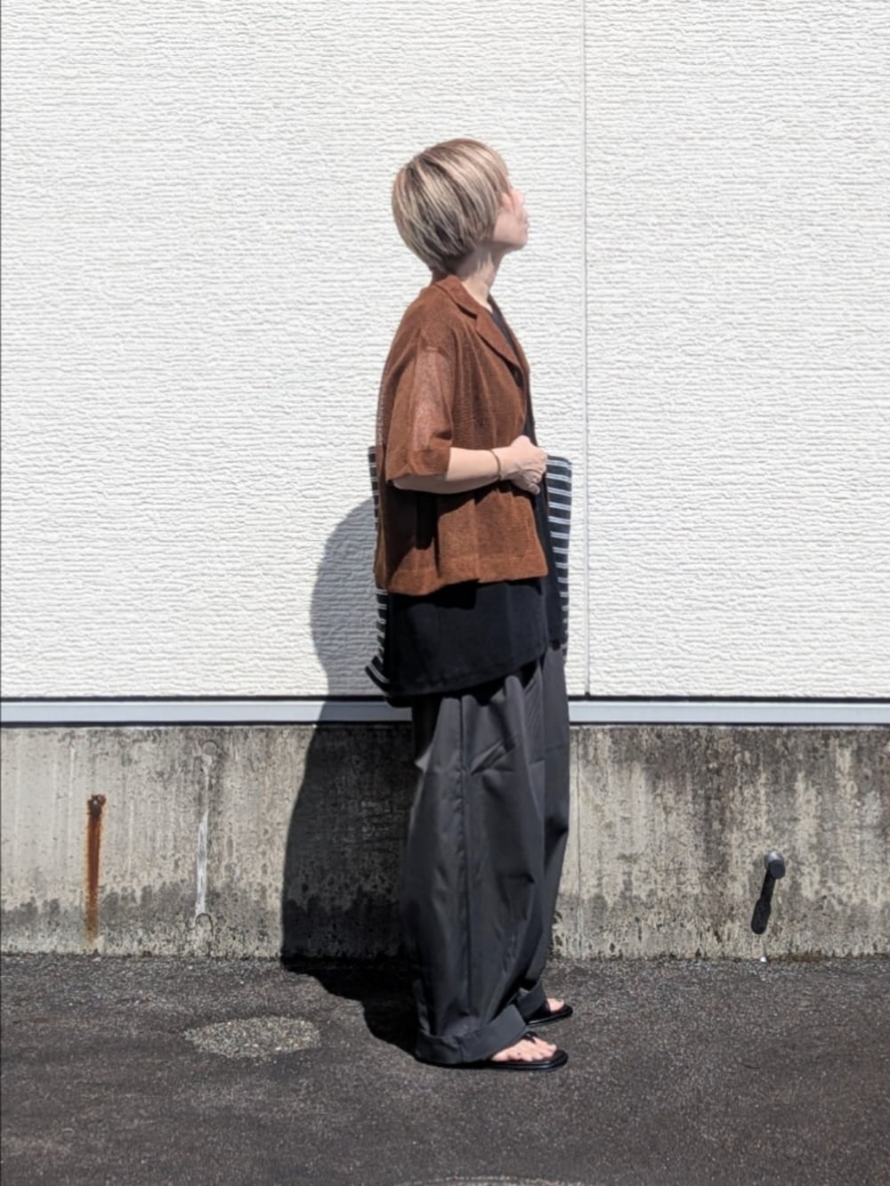 ブラック系のTシャツ/カットソー、グレー系のその他パンツ、ブラック系のサンダルを着用したレディースの夏コーディネートの3枚目の写真