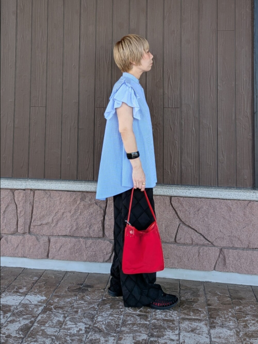 ブルー系のシャツ/ブラウス、ブラック系のその他パンツ、レッド系のショルダーバッグを着用したレディースの夏コーディネートの2枚目の写真