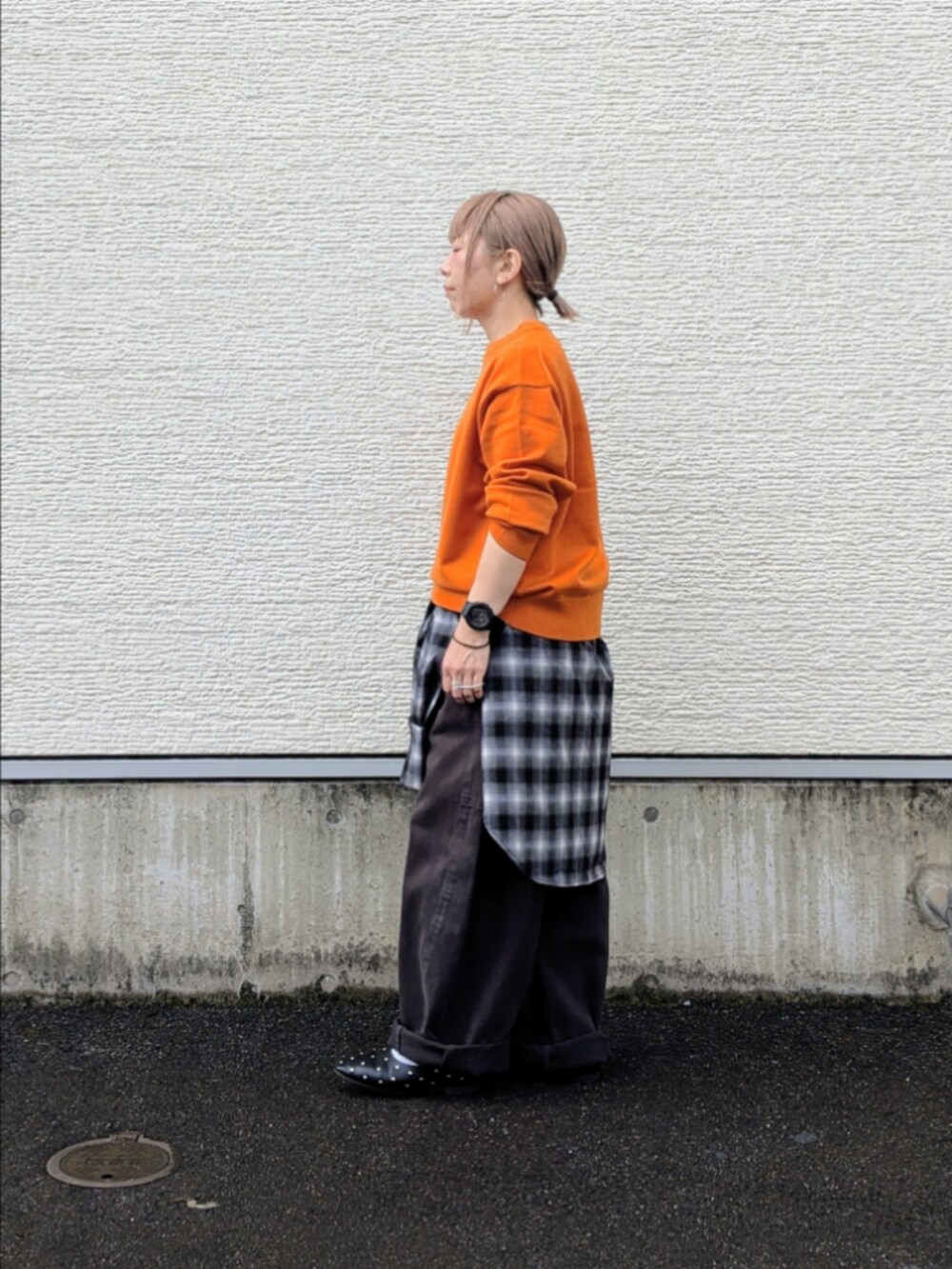 オレンジ系のニット/セーター、ブラック系のシャツ/ブラウス、グレー系のその他パンツを着用したレディースの秋コーディネートの3枚目の写真
