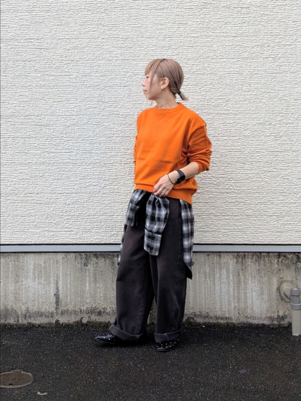 オレンジ系のニット/セーター、ブラック系のシャツ/ブラウス、グレー系のその他パンツを着用したレディースの秋コーディネートの2枚目の写真