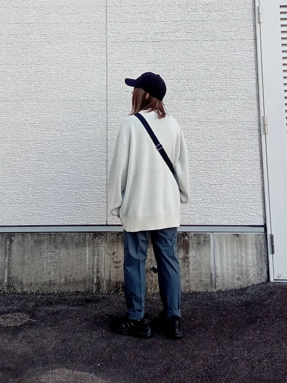 ブラック系のショルダーバッグ、ホワイト系のニット/セーター、グレー系のその他パンツを着用したレディースの秋コーディネートの3枚目の写真