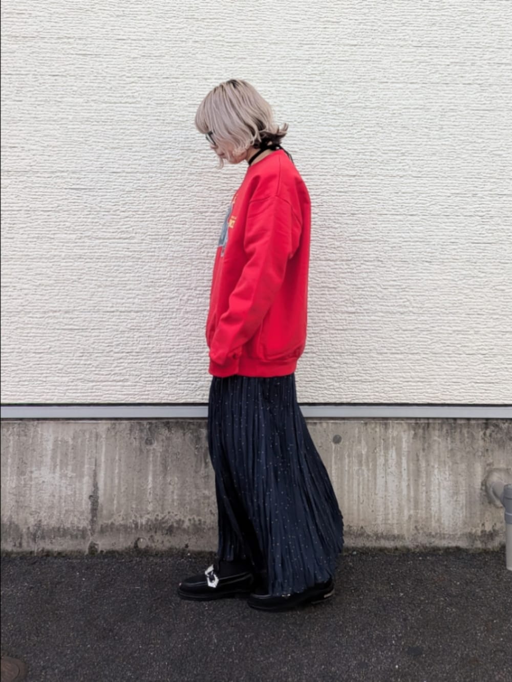 レッド系のスウェット、ブルー系のスカート、ブラック系のネックレスを着用したレディースの冬コーディネートの2枚目の写真