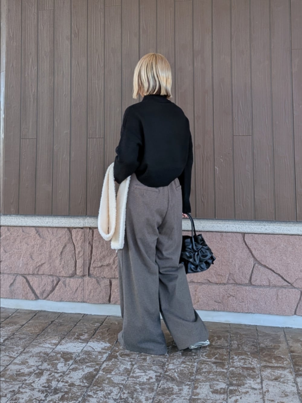 ブラック系のニット/セーター、ブラック系のその他パンツ、ブラック系のハンドバッグを着用したレディースの冬コーディネートの3枚目の写真