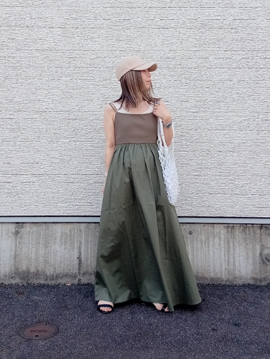 ホワイト系のバッグ、グリーン系のワンピース、ベージュ系のキャップを着用したレディースの夏コーディネートの3枚目の写真