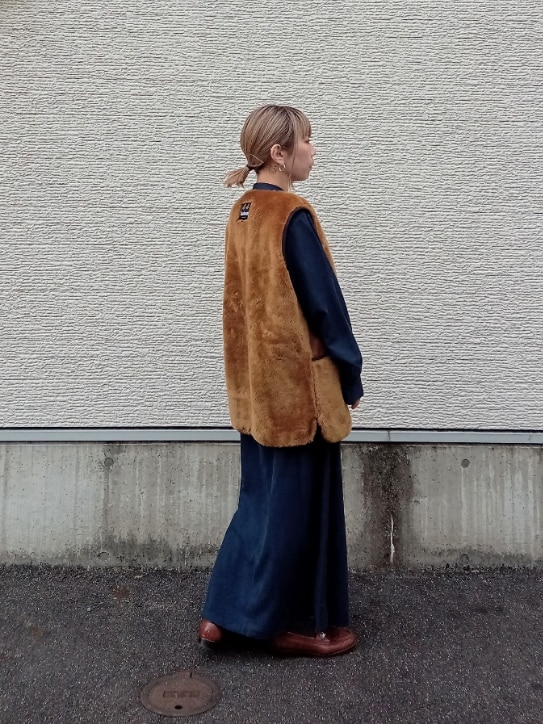 ブラウン系のベスト、ブルー系のワンピースを着用したレディースの冬コーディネートの3枚目の写真