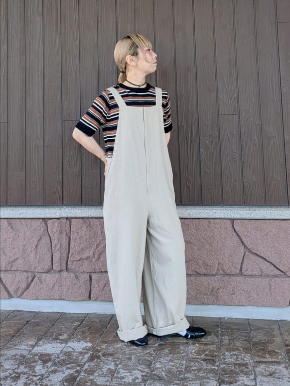 ベージュ系のサロペット/オーバーオール、ブラウン系のニット/セーター、ブラック系のサンダルを着用したレディースの春コーディネートの3枚目の写真