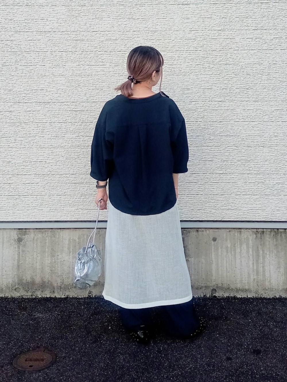 ホワイト系のスカート、ブラック系のパンプス、シルバー系のショルダーバッグを着用したレディースの春コーディネートの4枚目の写真