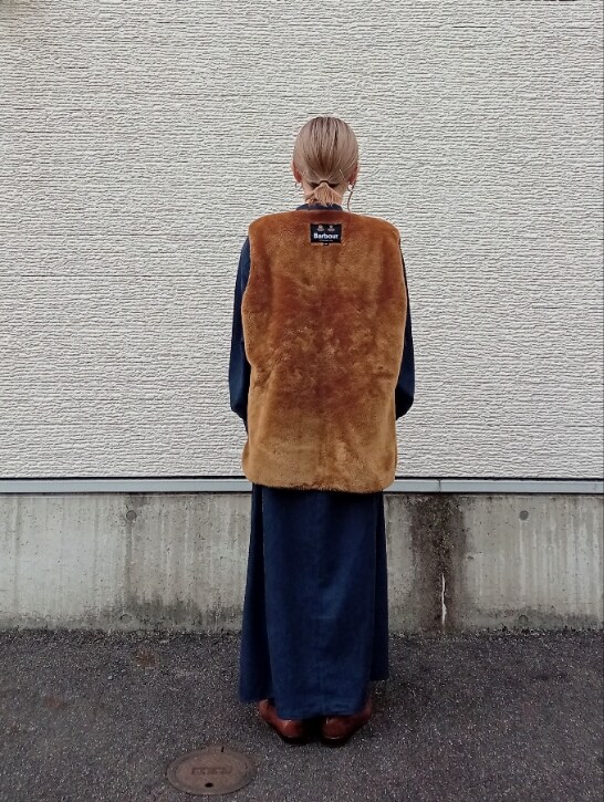 ブラウン系のベスト、ブルー系のワンピースを着用したレディースの冬コーディネートの4枚目の写真