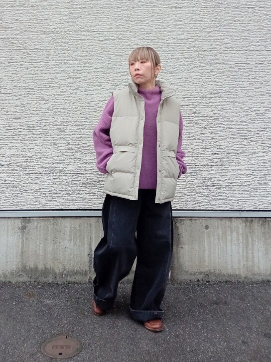 パープル系のニット/セーター、ベージュ系のダウンベスト、ブラック系のデニムパンツを着用したレディースの冬コーディネートの3枚目の写真