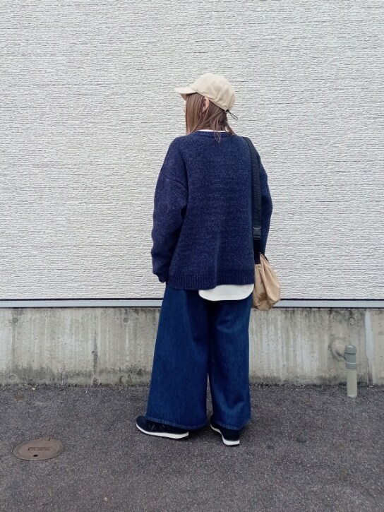 ブルー系のニット/セーター、ホワイト系のTシャツ/カットソー、ベージュ系のショルダーバッグを着用したレディースの秋コーディネートの5枚目の写真