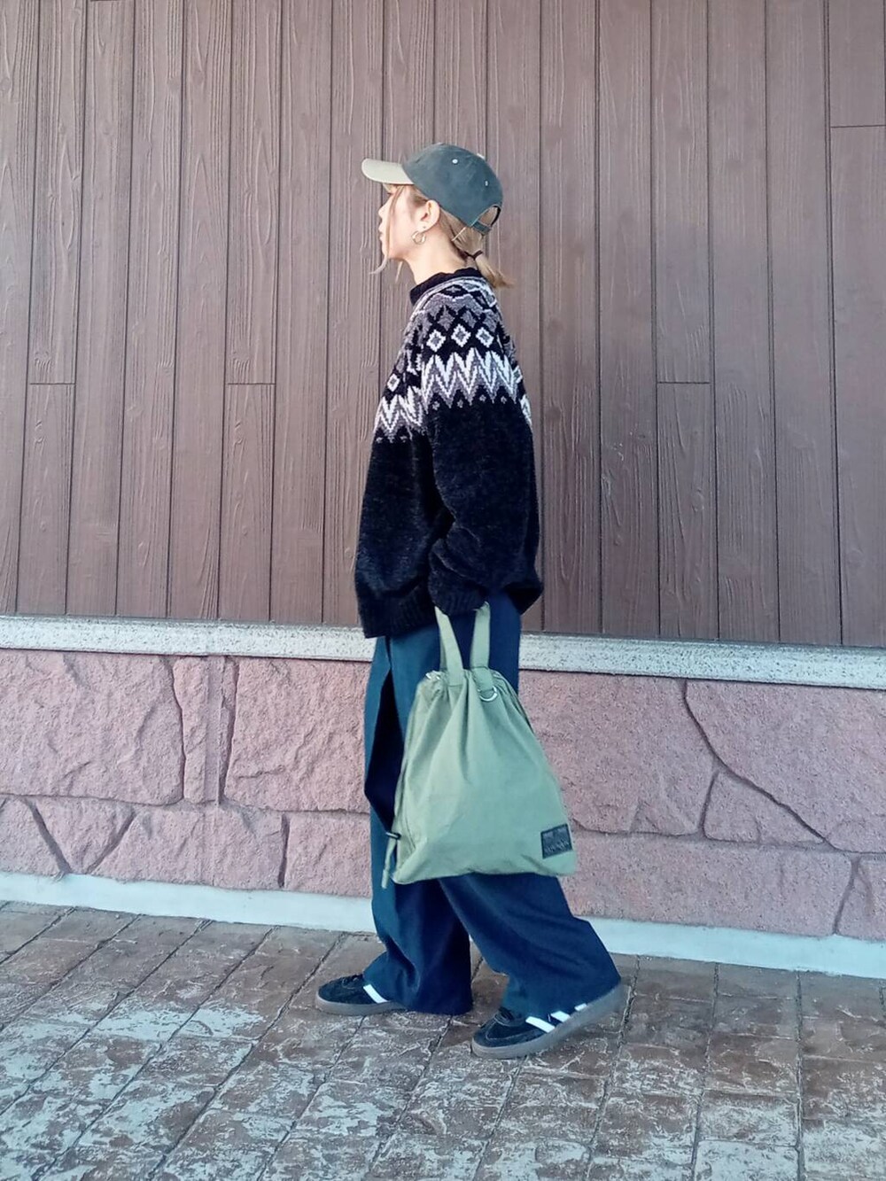 ブルー系のその他パンツ、グリーン系のショルダーバッグ、ブラック系のニット/セーターを着用したレディースの冬コーディネートの4枚目の写真