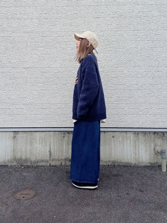 ブルー系のニット/セーター、ホワイト系のTシャツ/カットソー、ベージュ系のショルダーバッグを着用したレディースの秋コーディネートの4枚目の写真