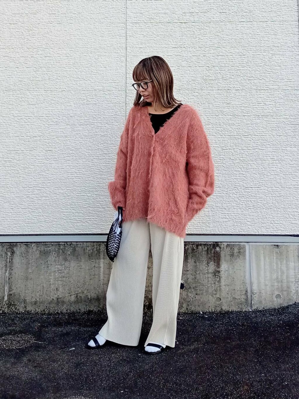 ホワイト系のその他パンツ、ブラック系のタンクトップ、オレンジ系のカーディガン/ボレロを着用したレディースの秋コーディネートの2枚目の写真