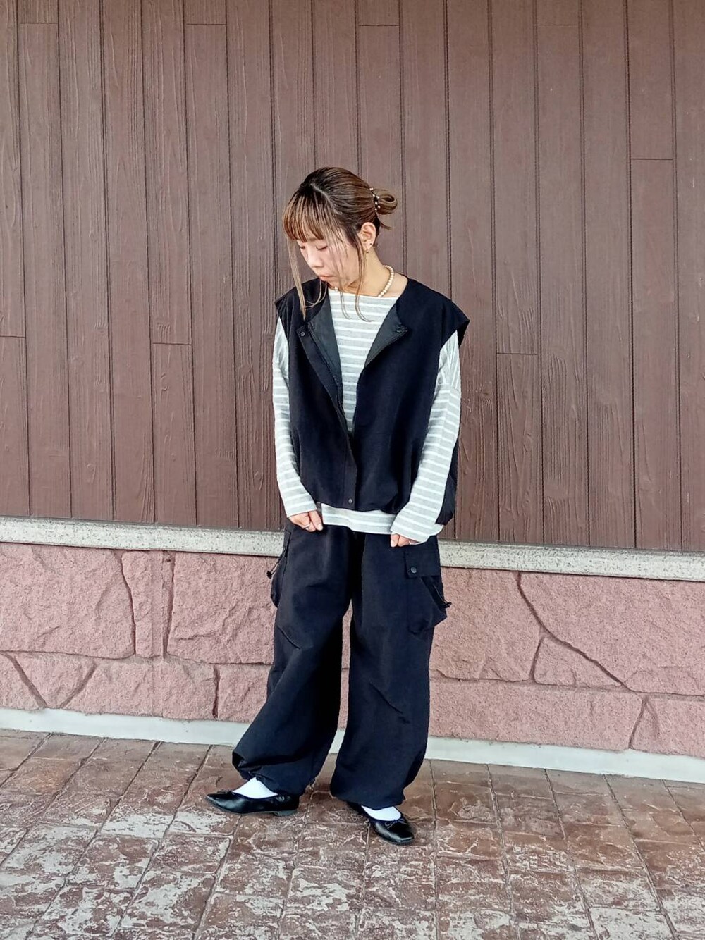 ブラック系のベスト、ブラック系のその他パンツ、グレー系のTシャツ/カットソーを着用したレディースの秋コーディネートの4枚目の写真