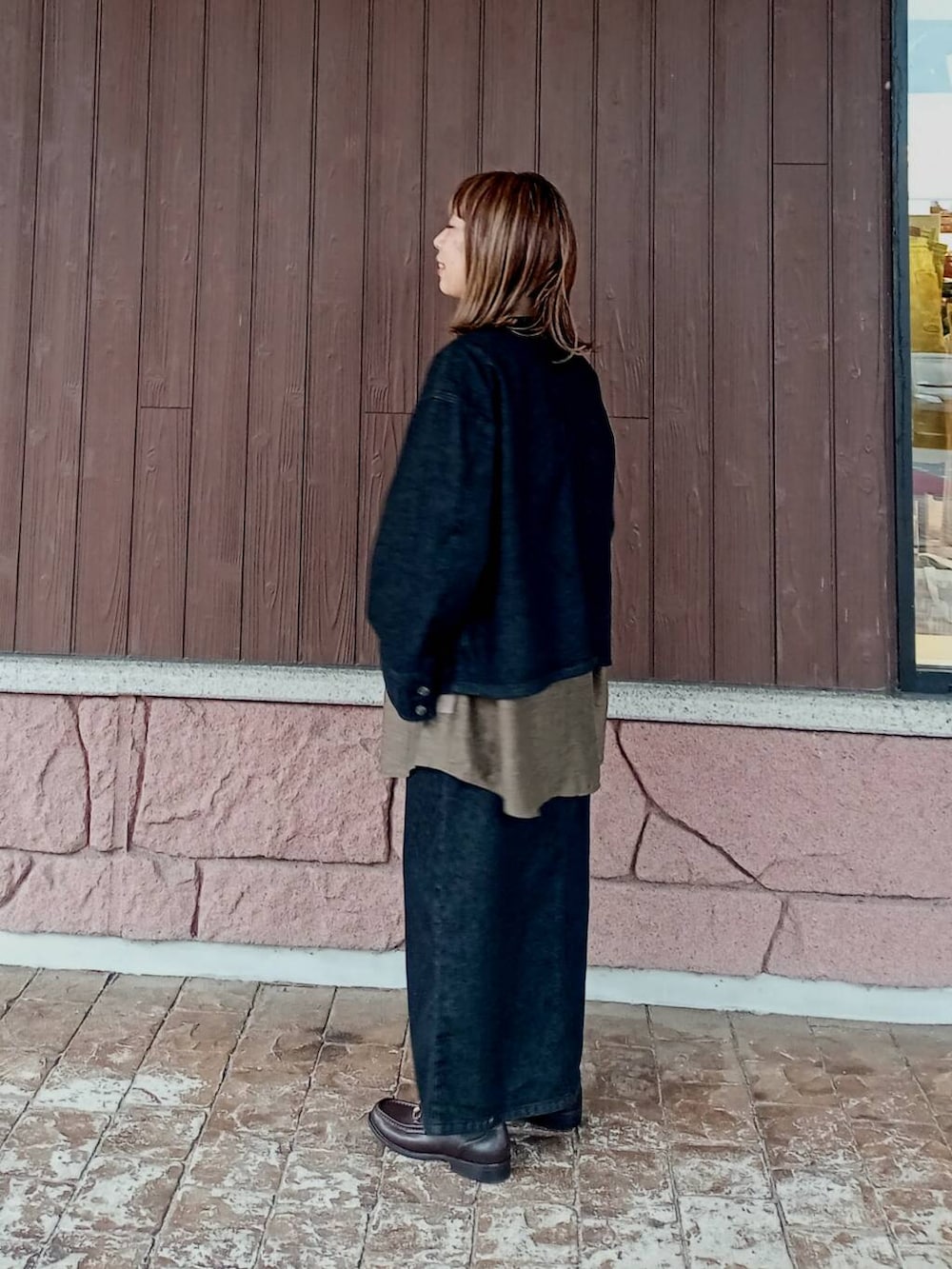 ブラウン系のローファー、ブラック系のスカート、ブラック系のデニムジャケットを着用したレディースの秋コーディネートの4枚目の写真