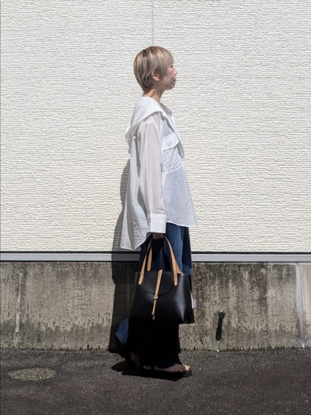 ホワイト系のシャツ/ブラウス、ブルー系のその他パンツ、ブラック系のハンドバッグを着用したレディースの夏コーディネートの2枚目の写真