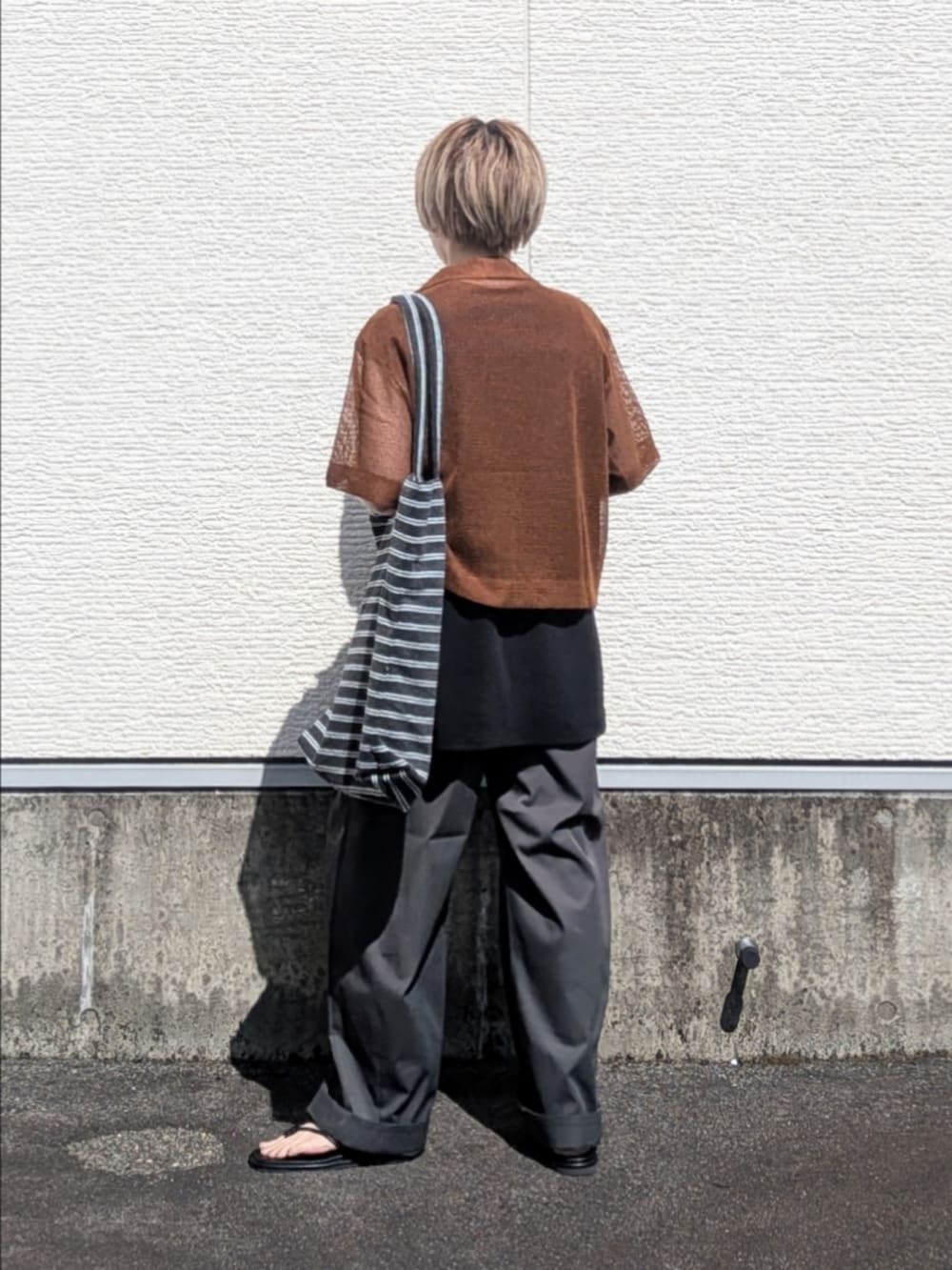 ブラック系のTシャツ/カットソー、グレー系のその他パンツ、ブラック系のサンダルを着用したレディースの夏コーディネートの4枚目の写真