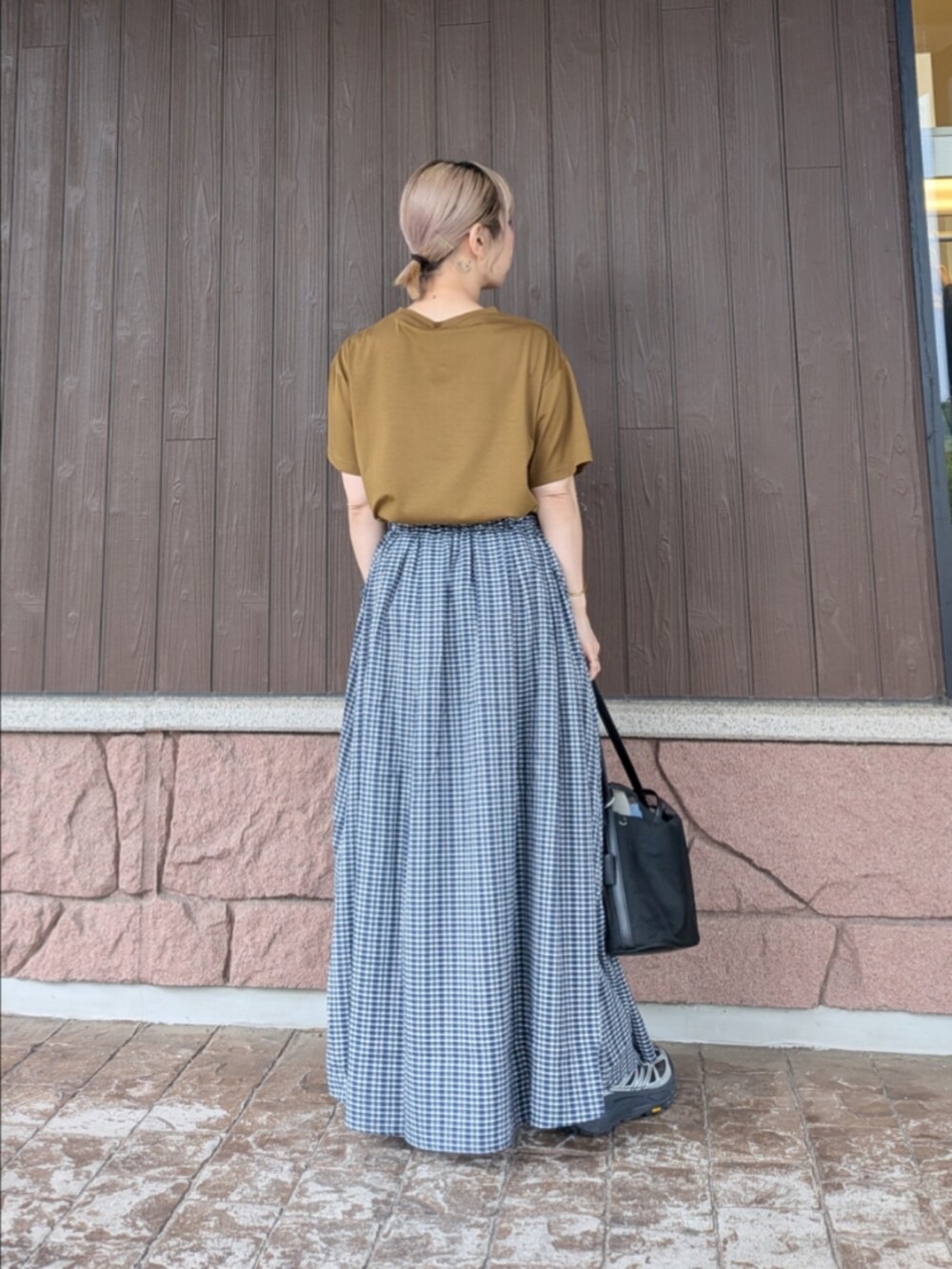 イエロー系のTシャツ/カットソー、ブラック系のスニーカー、ブラック系のショルダーバッグを着用したレディースの夏コーディネートの3枚目の写真