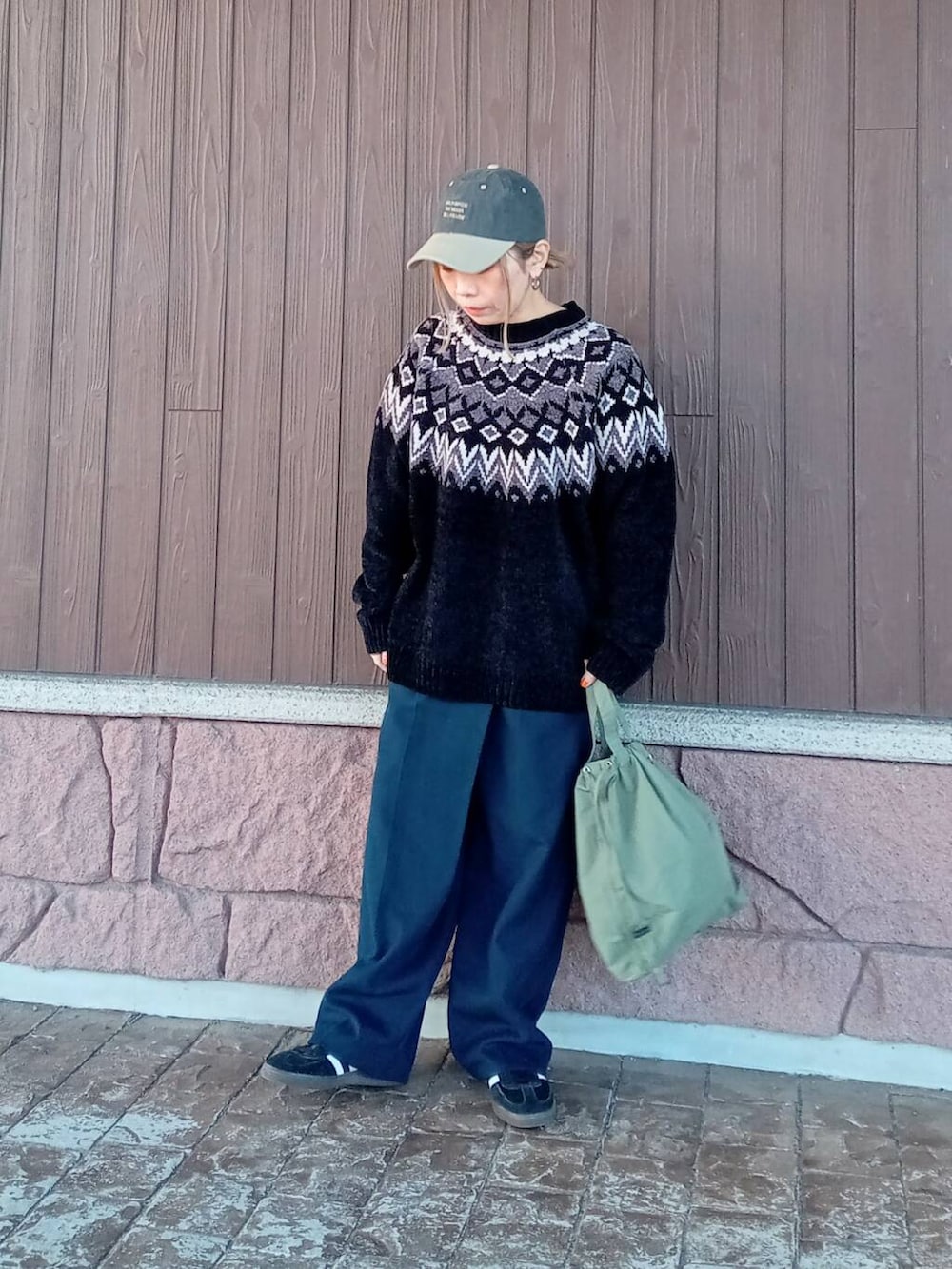 ブルー系のその他パンツ、グリーン系のショルダーバッグ、ブラック系のニット/セーターを着用したレディースの冬コーディネートの2枚目の写真