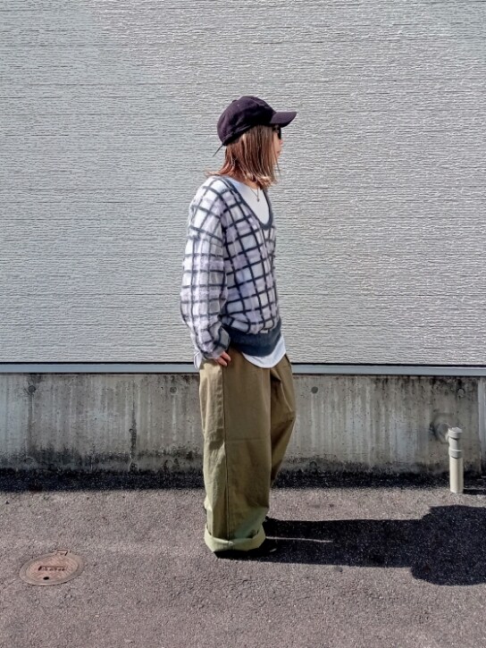 グレー系のニット/セーター、グリーン系のチノパンツ、ブラック系のキャップを着用したレディースの秋コーディネートの2枚目の写真