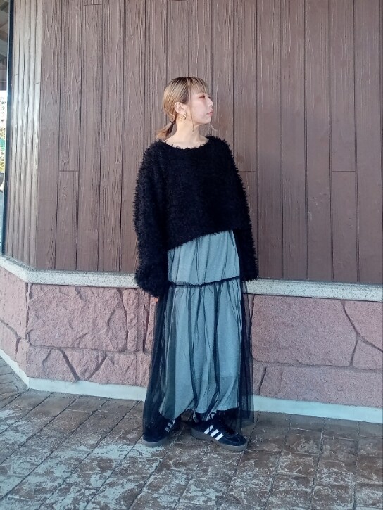 ブラック系のニット/セーター、シルバー系のスカート、ブラック系のスニーカーを着用したレディースの冬コーディネートの5枚目の写真