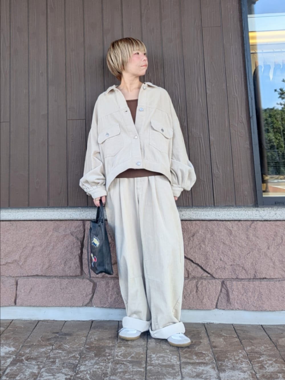 ホワイト系のカバーオール、ホワイト系のその他パンツ、ブラウン系のニット/セーターを着用したレディースの秋コーディネートの5枚目の写真