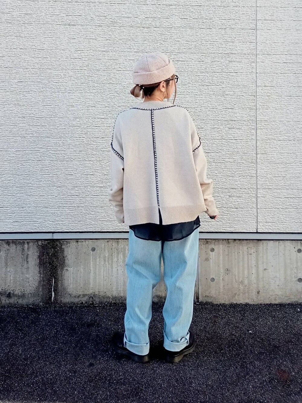 ブルー系のデニムパンツ、ホワイト系のニット/セーター、ブラック系のシャツ/ブラウスを着用したレディースの秋コーディネートの5枚目の写真