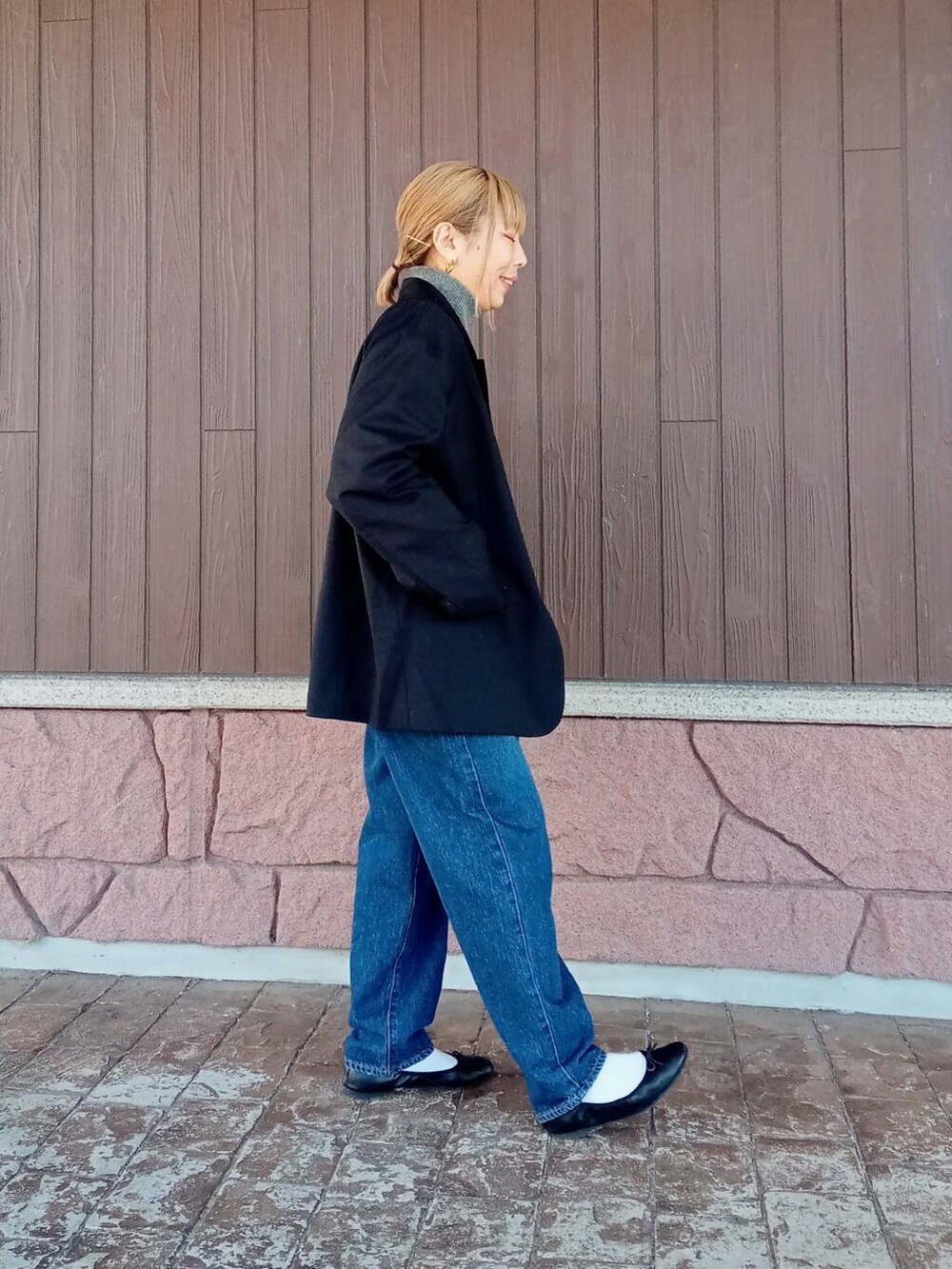 ブルー系のデニムパンツ、ブラック系のその他アウター、グレー系のニット/セーターを着用したレディースの冬コーディネートの2枚目の写真