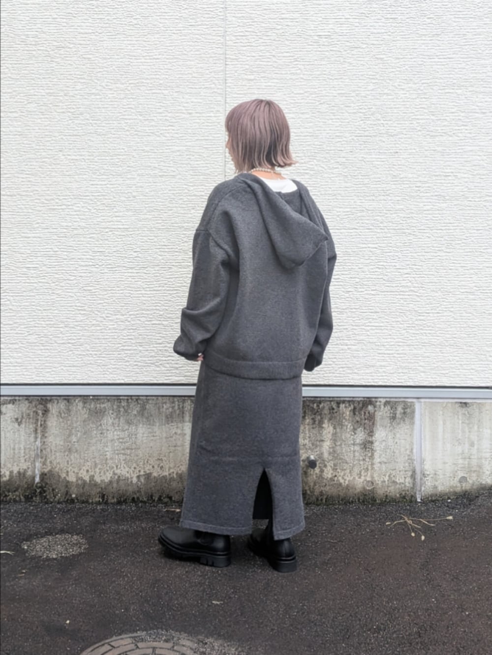 グレー系のニット/セーター、グレー系のスカート、ホワイト系のTシャツ/カットソーを着用したレディースの秋コーディネートの4枚目の写真