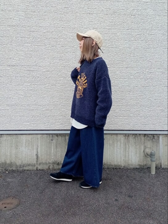 ブルー系のニット/セーター、ホワイト系のTシャツ/カットソー、ベージュ系のショルダーバッグを着用したレディースの秋コーディネートの3枚目の写真