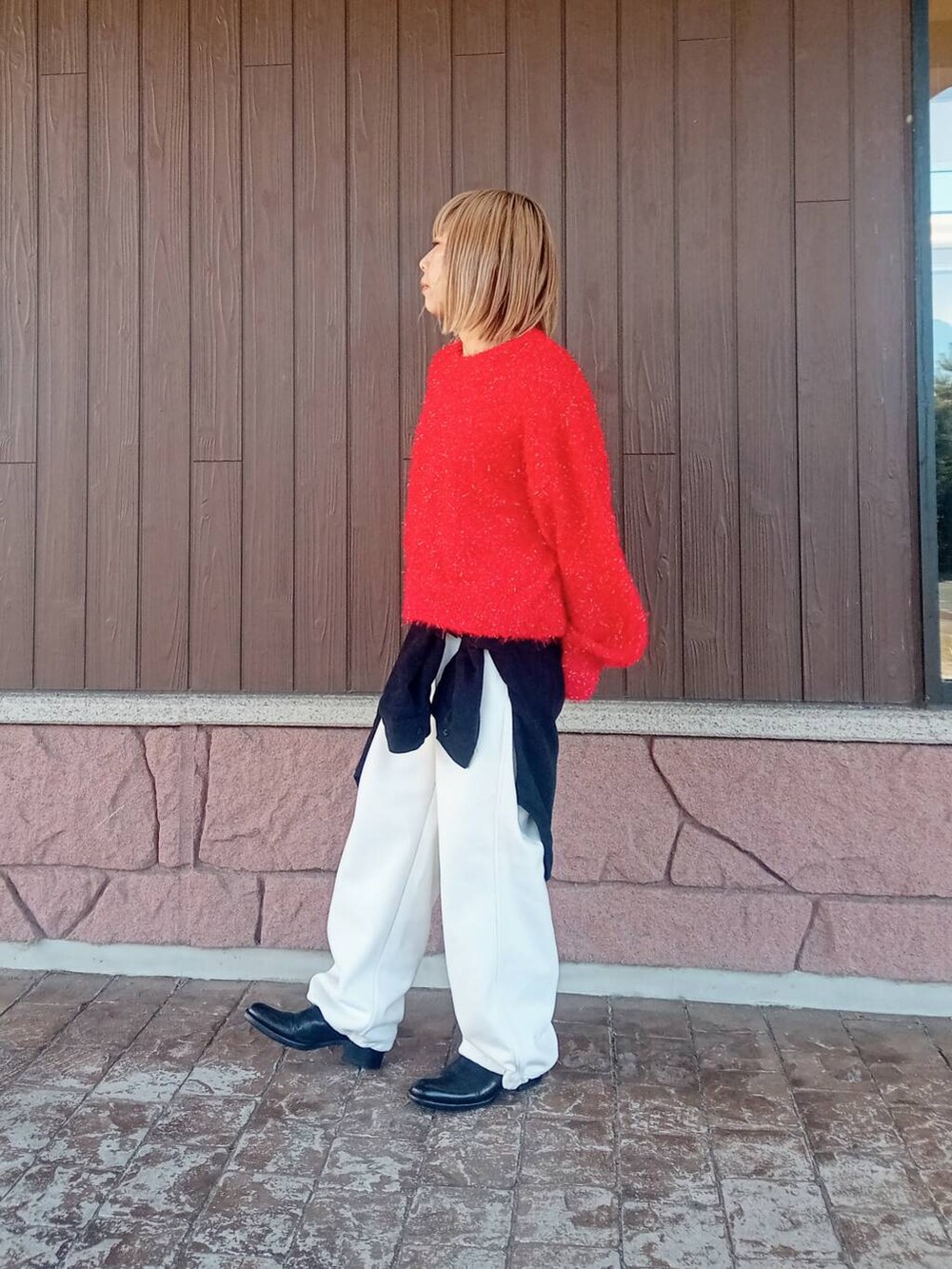 ブラック系のTシャツ/カットソー、ホワイト系のその他パンツ、レッド系のニット/セーターを着用したレディースの冬コーディネートの2枚目の写真