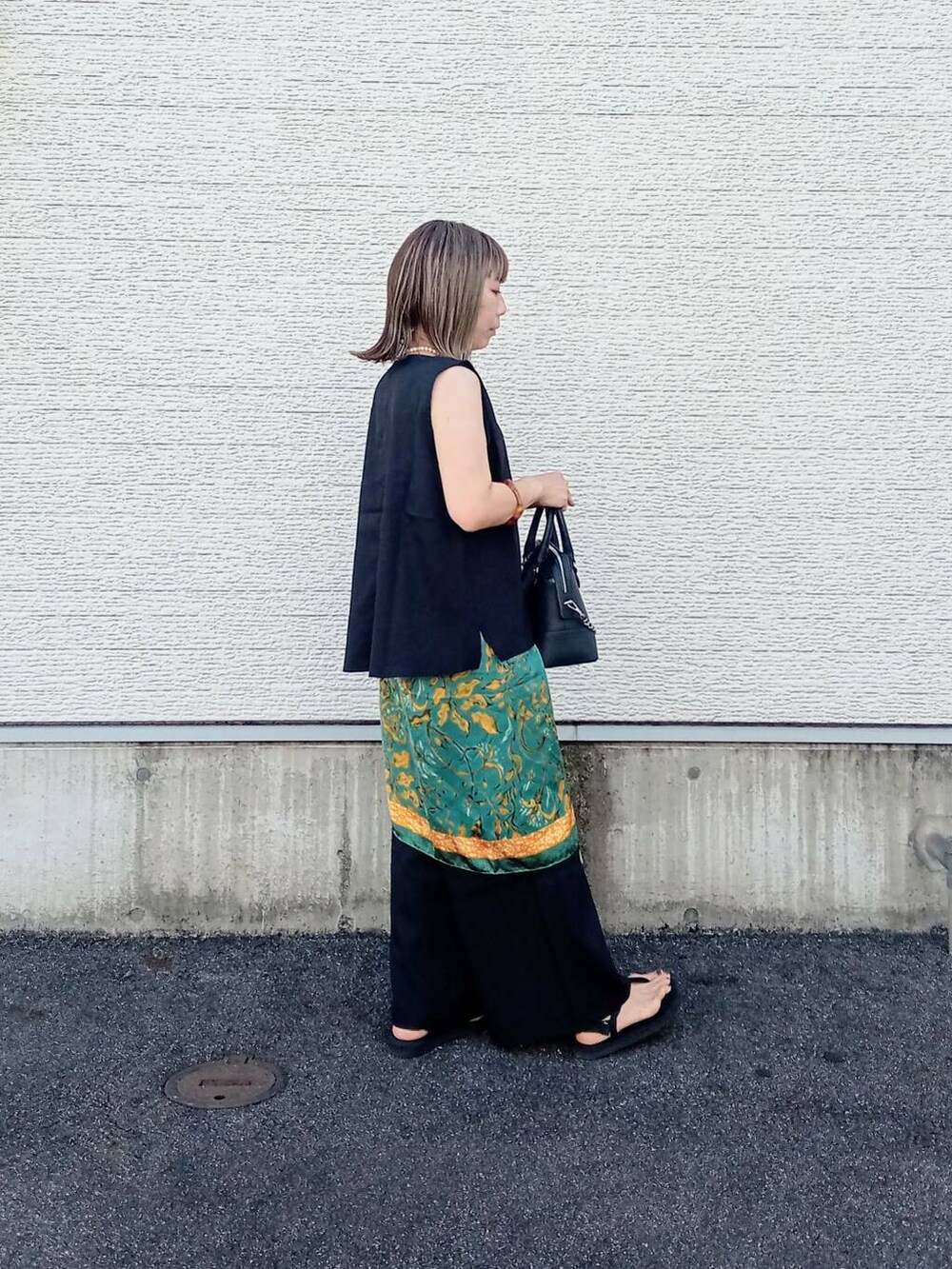 ブラック系のサロペット/オーバーオール、ブラック系のボストンバッグ、ブラック系のサンダルを着用したレディースの夏コーディネートの5枚目の写真