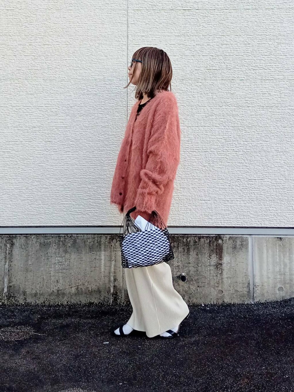 ホワイト系のその他パンツ、ブラック系のタンクトップ、オレンジ系のカーディガン/ボレロを着用したレディースの秋コーディネートの3枚目の写真