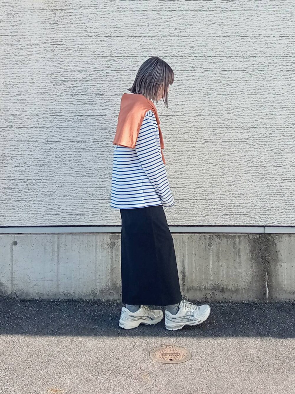 ブラック系のスカート、ブルー系のTシャツ/カットソー、オレンジ系のカーディガン/ボレロを着用したレディースの春コーディネートの3枚目の写真