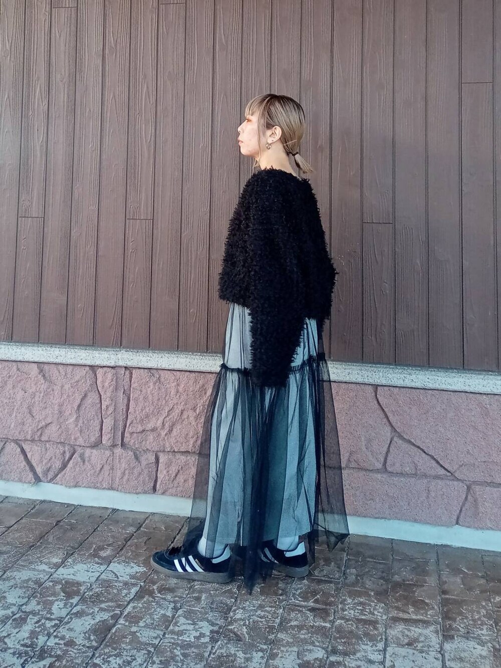 シルバー系のスカート、ブラック系のニット/セーターを着用したレディースの冬コーディネートの3枚目の写真