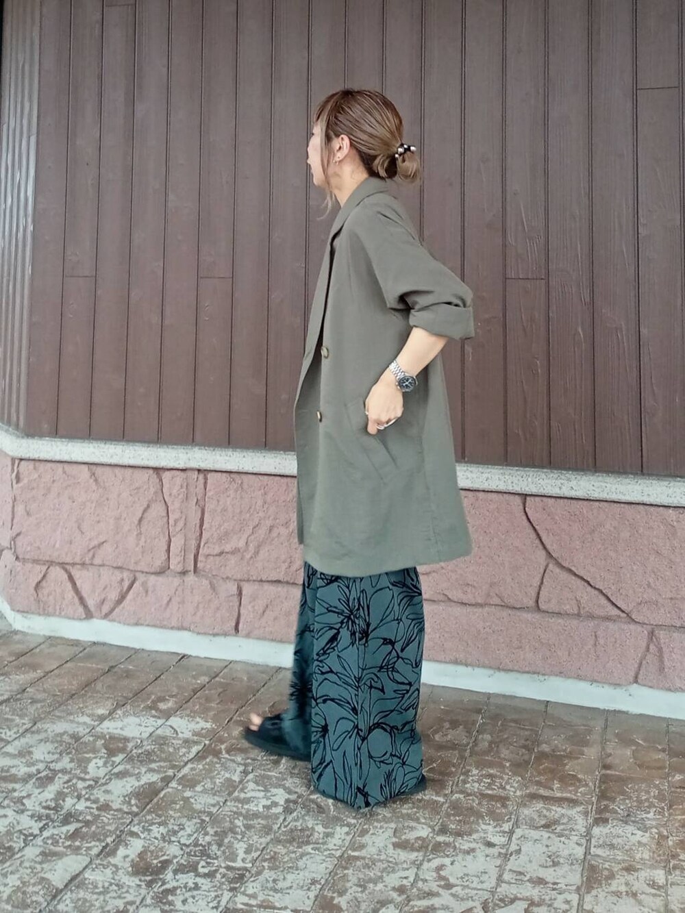 グリーン系のテーラードジャケット、ブラック系のニット/セーター、ブラウン系のその他パンツを着用したレディースの夏コーディネートの3枚目の写真