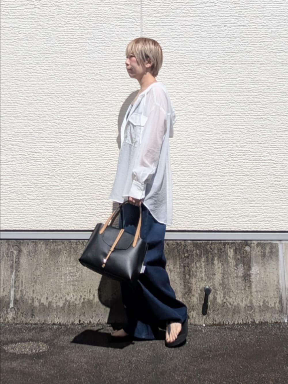 ホワイト系のシャツ/ブラウス、ブルー系のその他パンツ、ブラック系のハンドバッグを着用したレディースの夏コーディネートの5枚目の写真