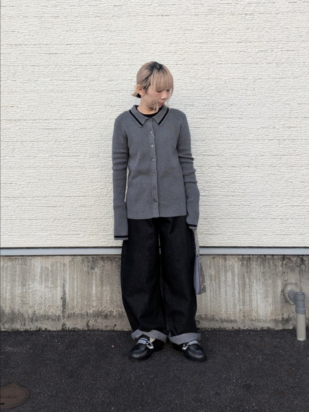 グレー系のニット/セーター、ブラック系のデニムパンツ、グレー系のハンドバッグを着用したレディースの冬コーディネートの3枚目の写真