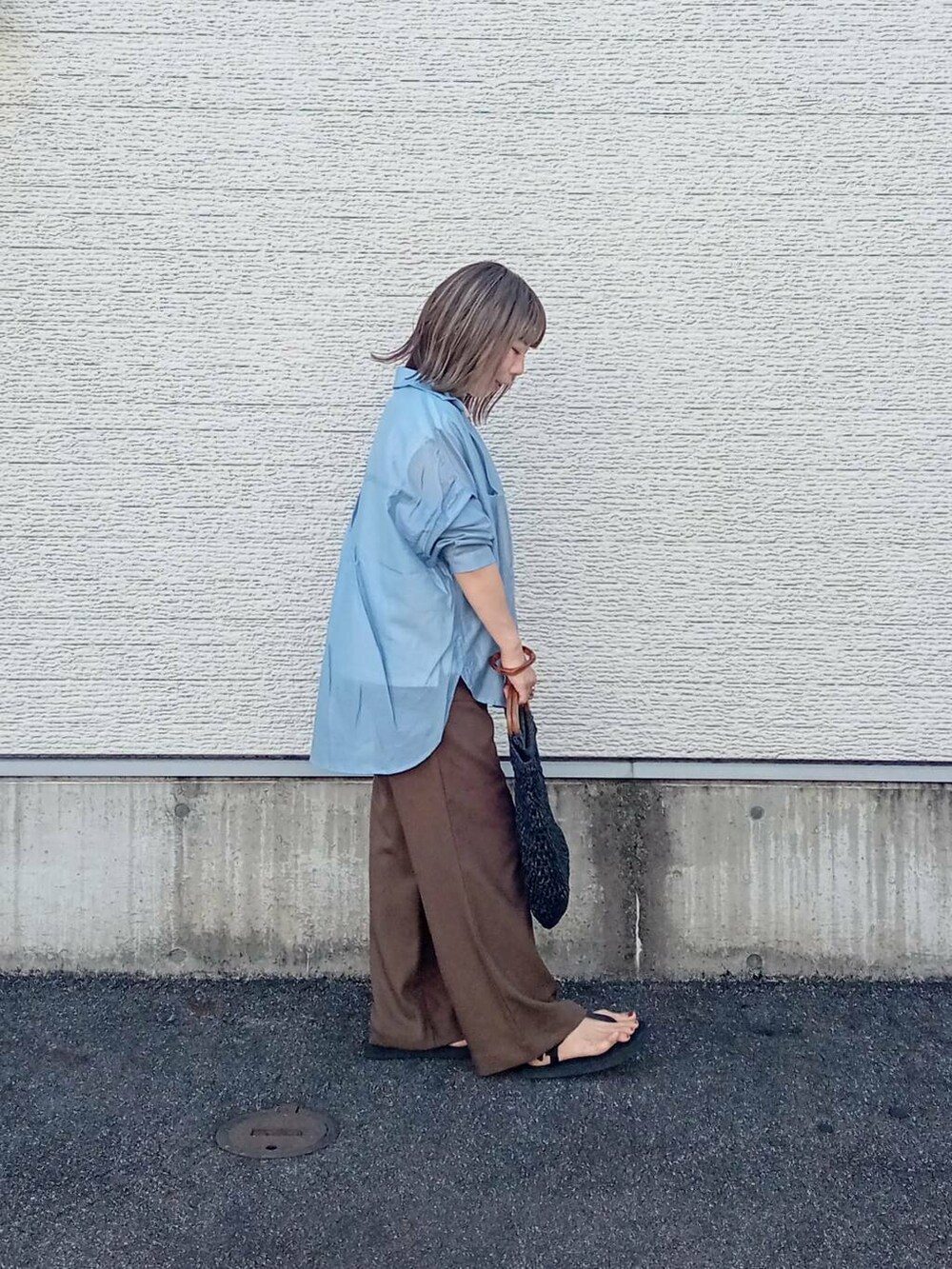 ブラック系のトートバッグ、ブルー系のシャツ/ブラウス、ホワイト系のTシャツ/カットソーを着用したレディースの夏コーディネートの3枚目の写真