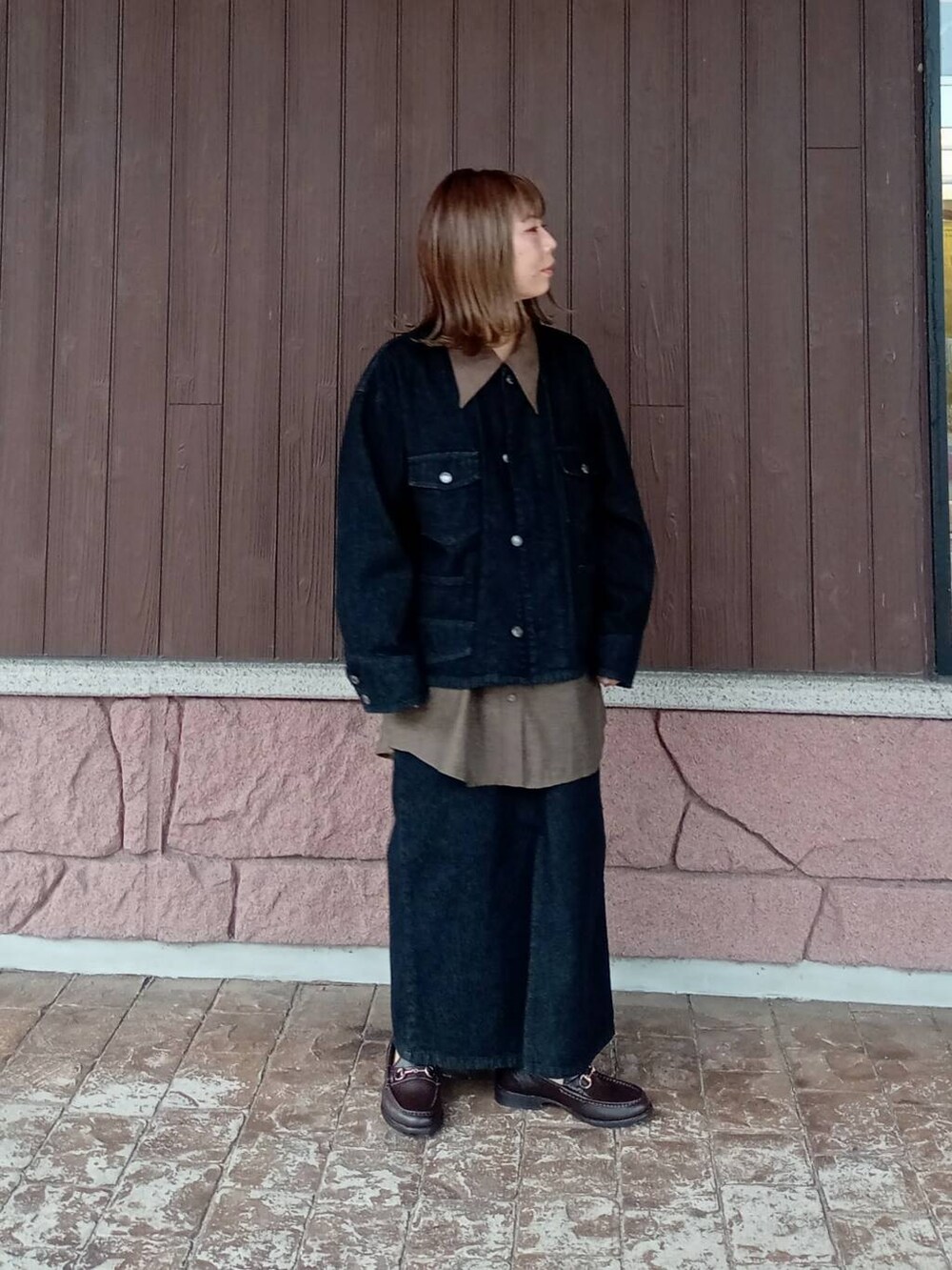 ブラウン系のローファー、ブラック系のスカート、ブラック系のデニムジャケットを着用したレディースの秋コーディネートの2枚目の写真