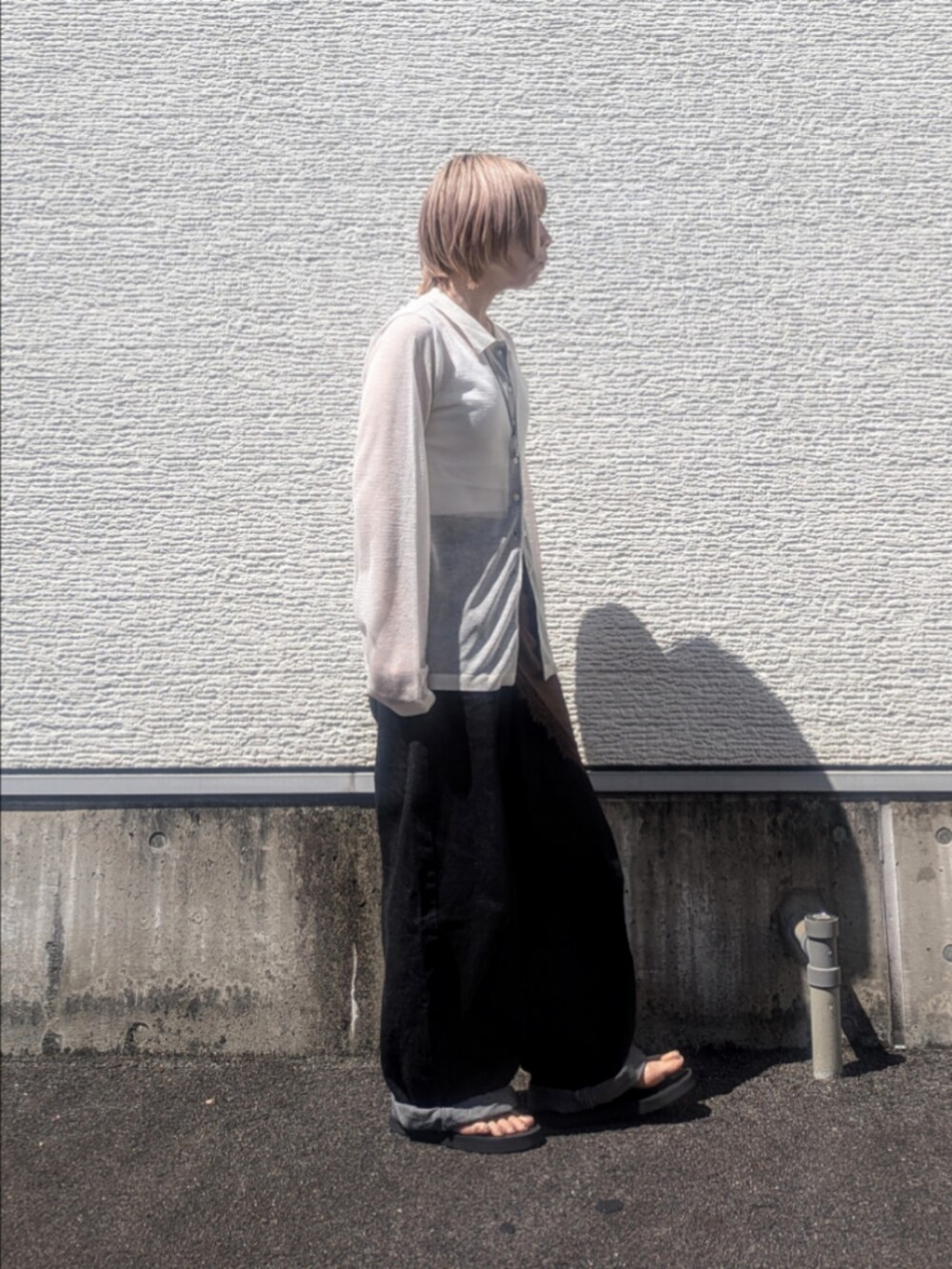 ホワイト系のニット/セーター、ブラック系のデニムパンツ、ブラウン系のバンダナ/スカーフを着用したレディースの夏コーディネートの2枚目の写真