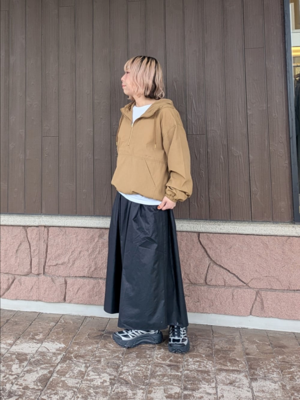 イエロー系のブルゾン、ブラック系のスカート、ブラック系のスニーカーを着用したレディースの春コーディネートの4枚目の写真