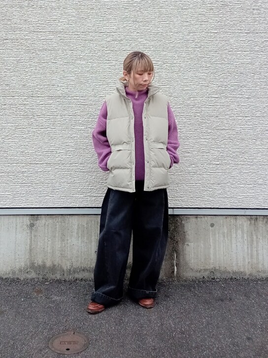 パープル系のニット/セーター、ベージュ系のダウンベスト、ブラック系のデニムパンツを着用したレディースの冬コーディネートの2枚目の写真