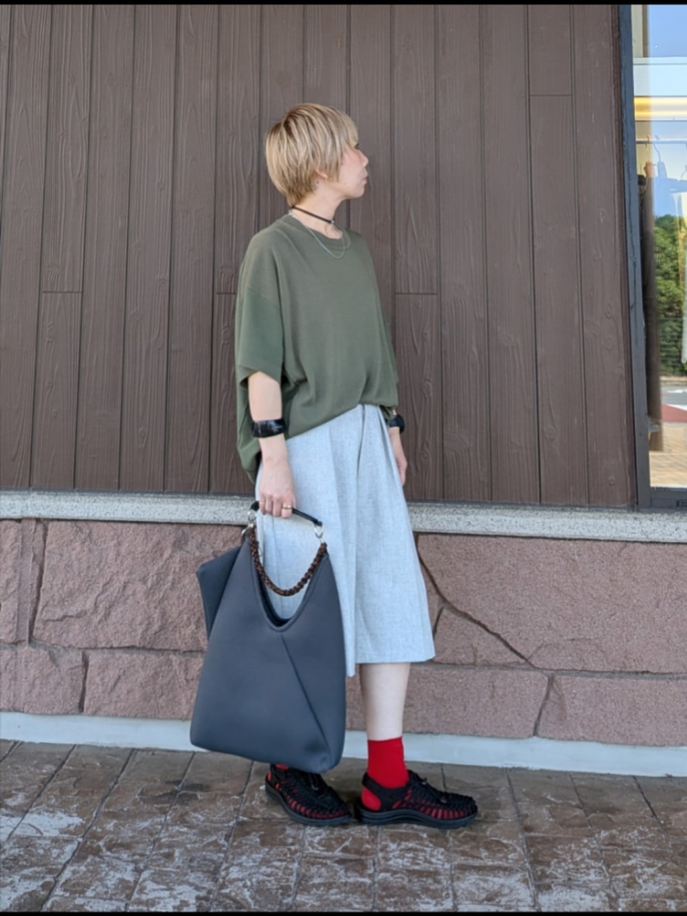 グリーン系のニット/セーター、グレー系のその他パンツ、ブラック系のサンダルを着用したレディースの夏コーディネートの2枚目の写真