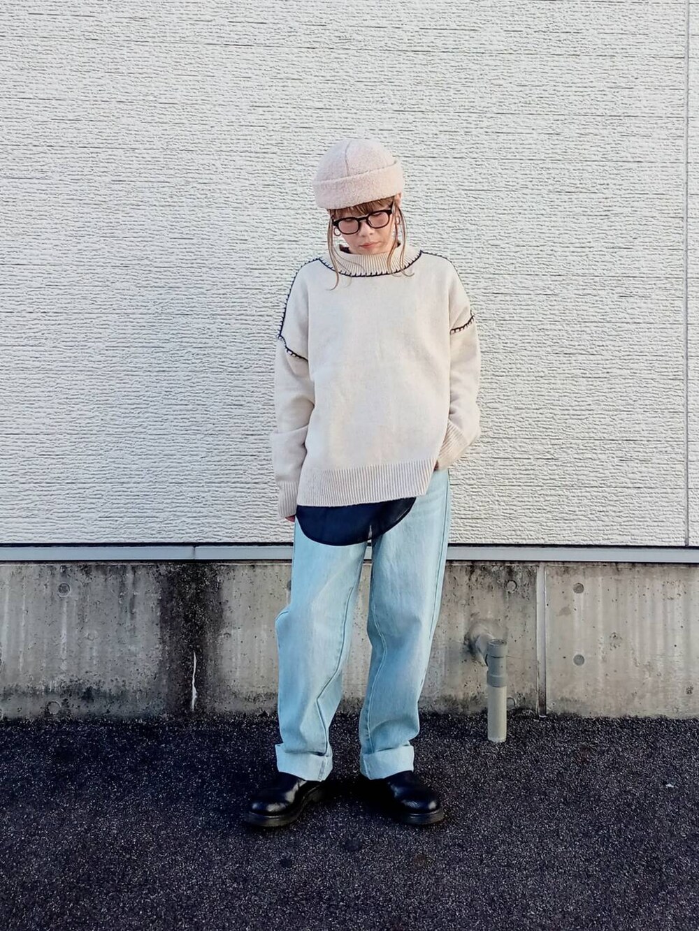 ブルー系のデニムパンツ、ホワイト系のニット/セーター、ブラック系のシャツ/ブラウスを着用したレディースの秋コーディネートの2枚目の写真