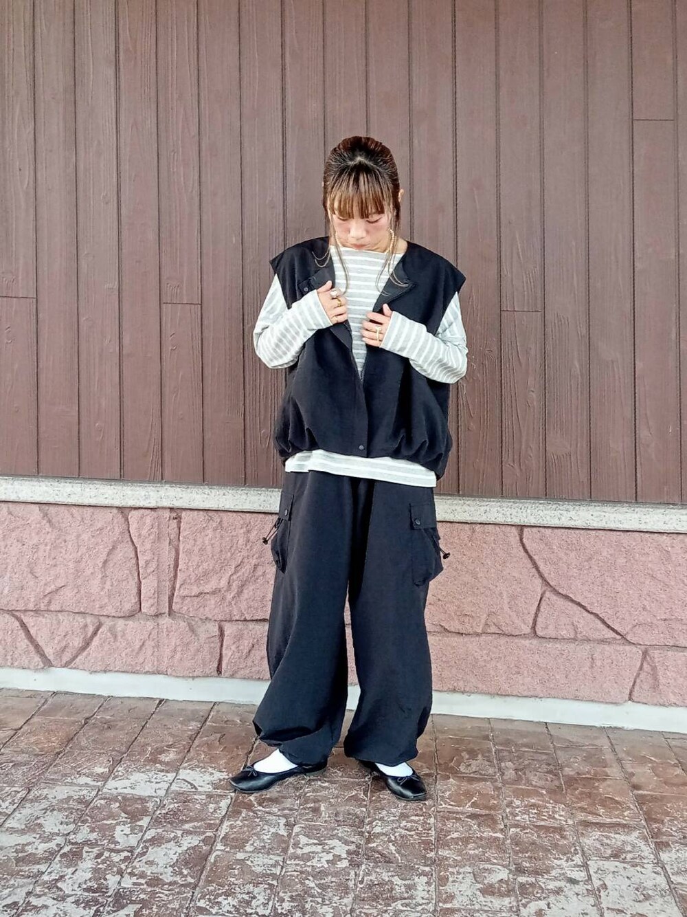 ブラック系のベスト、ブラック系のその他パンツ、グレー系のTシャツ/カットソーを着用したレディースの秋コーディネートの2枚目の写真