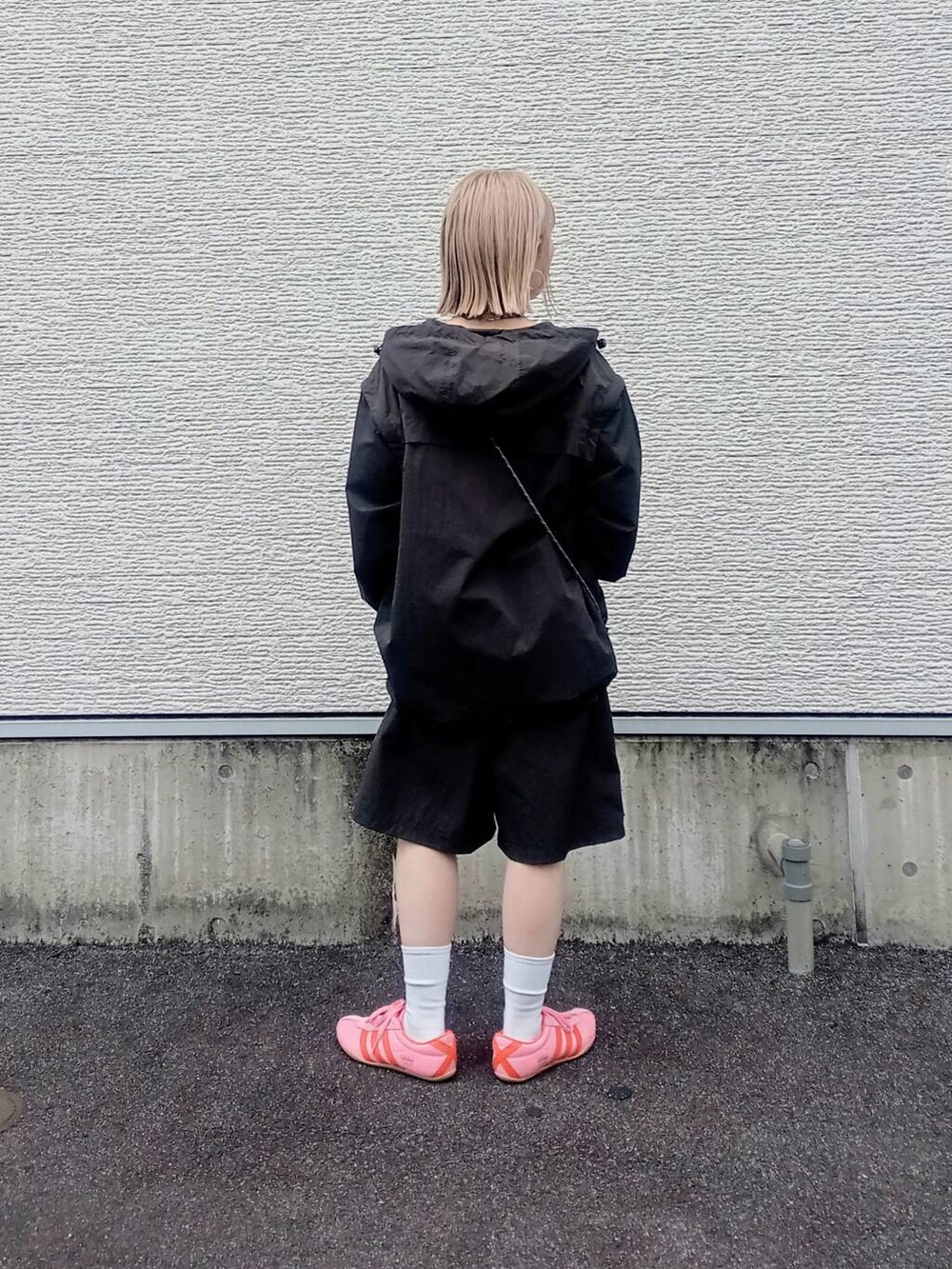 ブラック系のショルダーバッグ、グレー系のマウンテンパーカーを着用したレディースの春コーディネートの3枚目の写真
