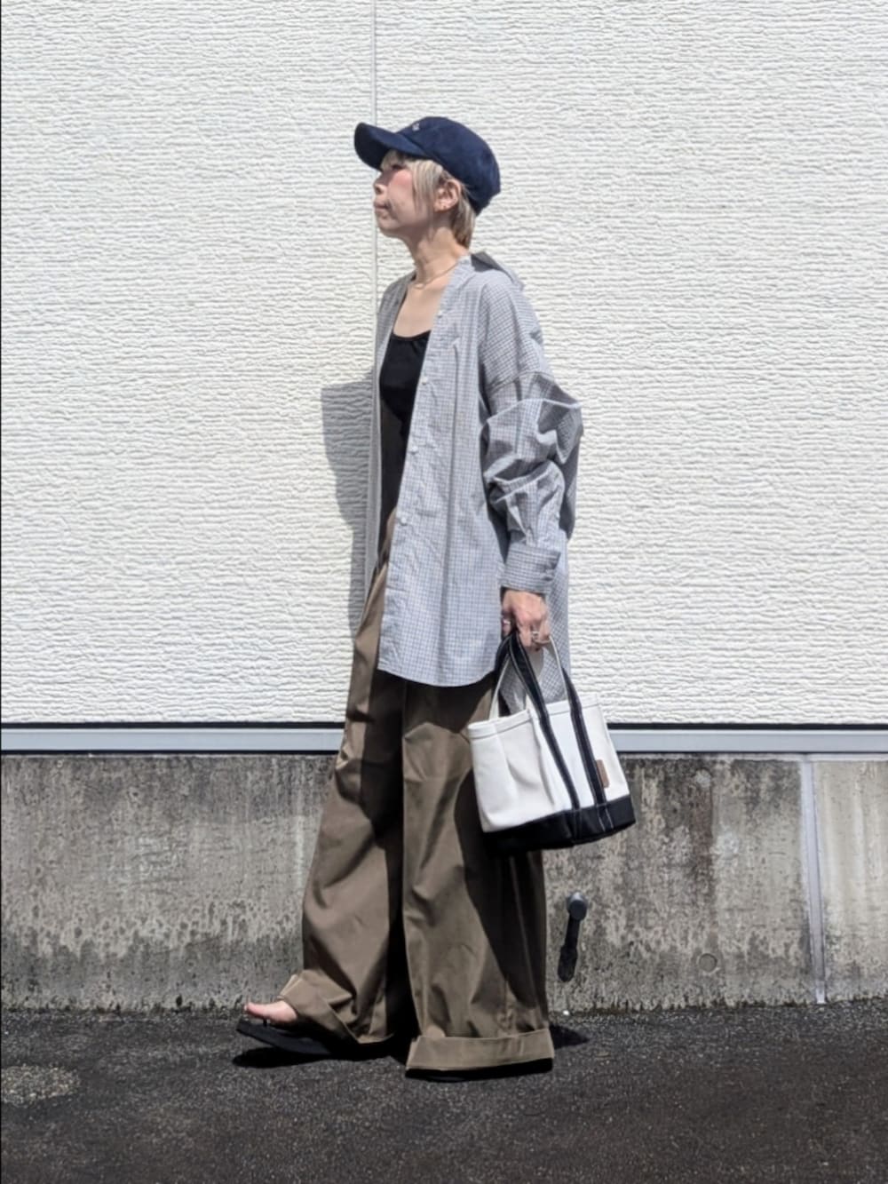 ブルー系のシャツ/ブラウス、ベージュ系のチノパンツ、ブラック系のトートバッグを着用したレディースの秋コーディネートの2枚目の写真