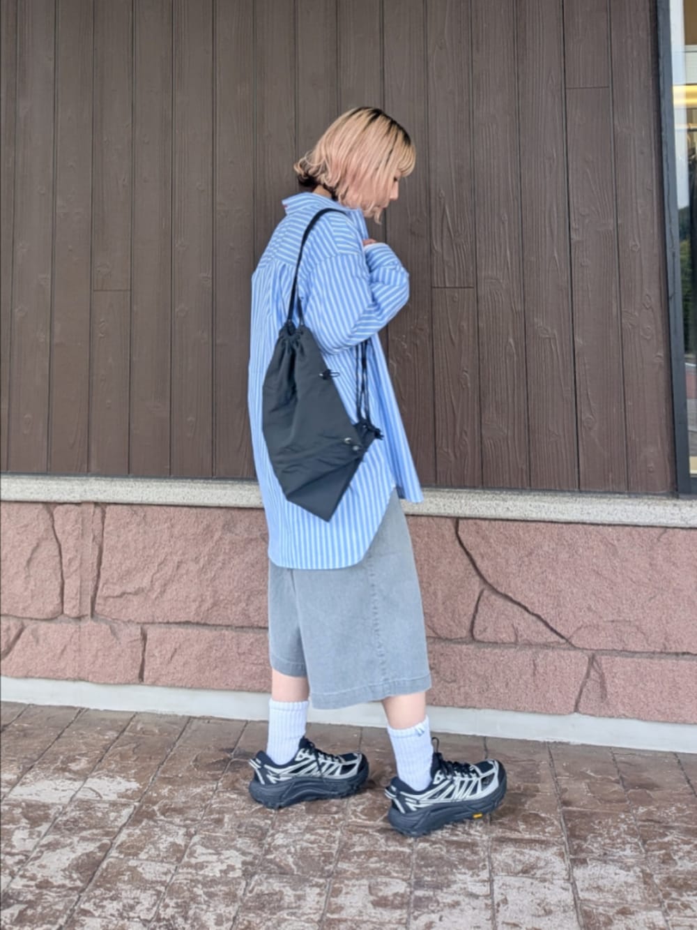 ブルー系のシャツ/ブラウス、グレー系のその他パンツ、ブラック系のスニーカーを着用したレディースの春コーディネートの4枚目の写真